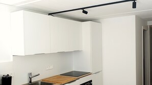 A modern kitchen with white cabinets, a wooden countertop, a sink, and a built-in oven. - Bright and spacious apartment for 6 people - View of the Flaine Forum (Arâches-la-Frasse)