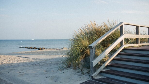 A wooden staircase leading to a sandy beach with a view of the ocean. - Cozy Cottage in Family Holiday Resort, Jezierzany (Postomino)