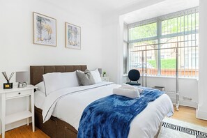 A modern bedroom with a large bed, a bedside table, a nightstand, a window with bars, and two framed artworks on the wall. - Leicester/1bedapart/petsok/wifi/tv/amenities (Leicester)