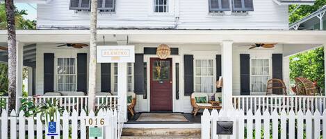 A white two-story house with a sign reading 'The Fleming Inn.'