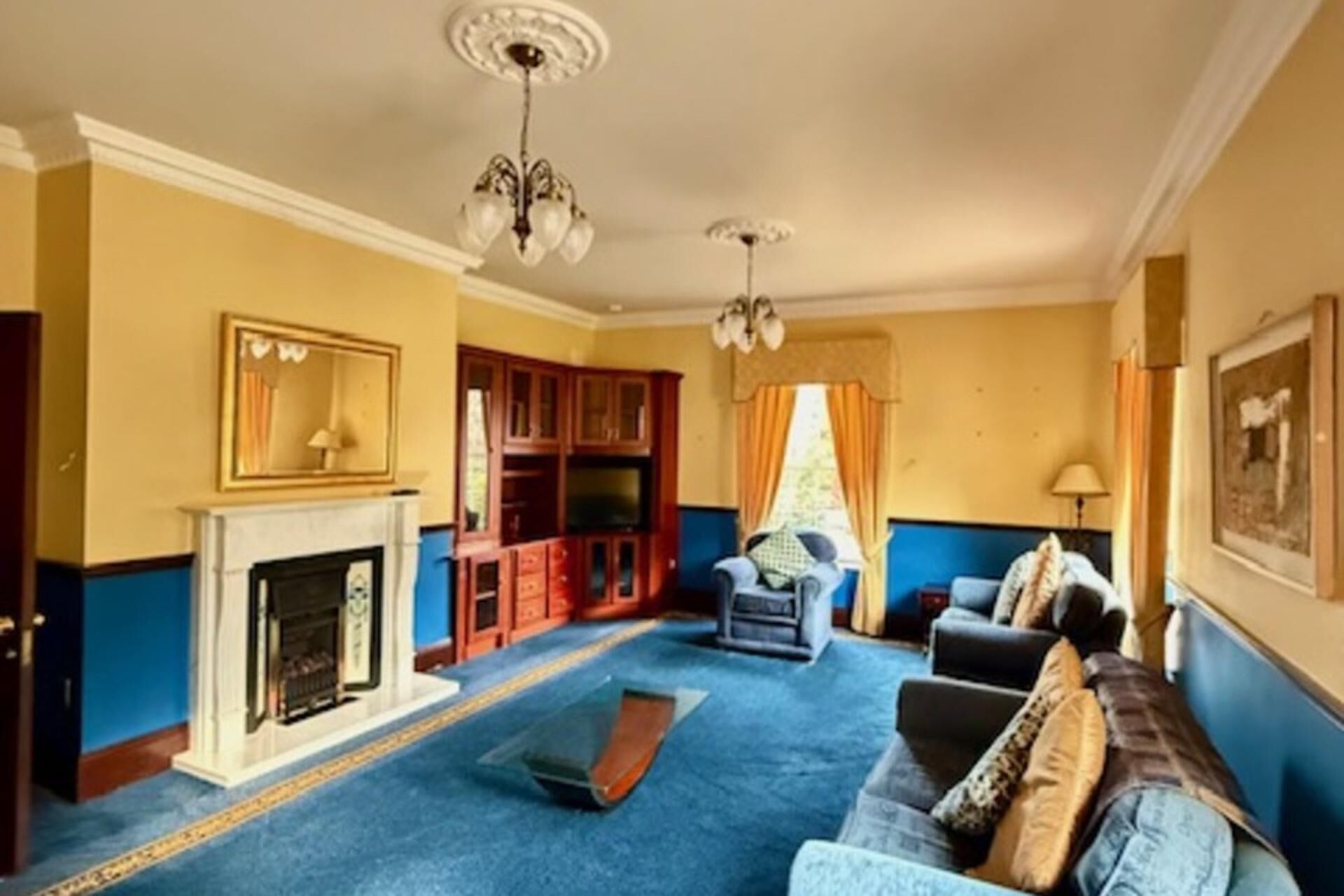 A living room with a fireplace, blue carpet, and a sofa.
