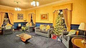 A cozy living room with two sofas, a coffee table, and a Christmas tree. - Summer Sale! Beakstown House Luxurious 5-bed Villa (Holycross)