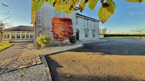 A stone building with a paved driveway and a well-maintained lawn. - Summer Sale! Beakstown House Luxurious 5-bed Villa (Holycross)