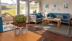 A cozy living room with a blue sofa, a wooden coffee table, and a potted plant. - 6 Person Holiday Home in Aabenraa-by Traum (Aabenraa)