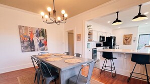 A dining area with a wooden table, grey chairs, and a woven placemat.