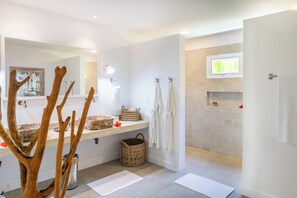 A modern bathroom with a large mirror, a sink, and a shower area. - Aldeia Beijupirá Pousada (Porto de Pedras)