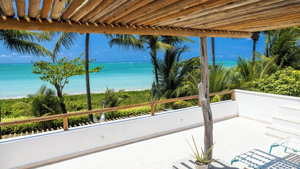 A balcony with a view of the ocean and palm trees. - Aldeia Beijupirá Pousada (Porto de Pedras)