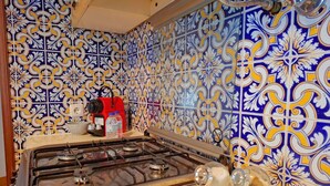 A kitchen with a gas stove, a sink, and a tiled backsplash. - PRAIA DA ROCHA – ATLÂNTICO III (Portimão)