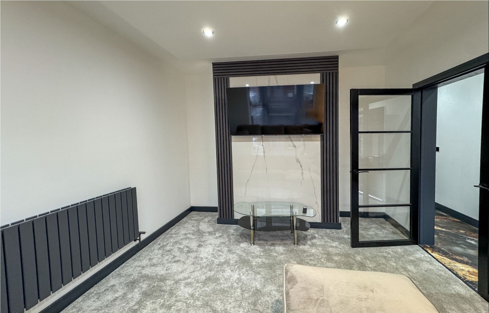 Une pièce moderne et compacte, dotée d’une cloison en verre, d’un radiateur et d’un banc rembourré.