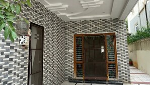 Moderne gevel met een patroonwand, glazen deur en betegelde vloer.