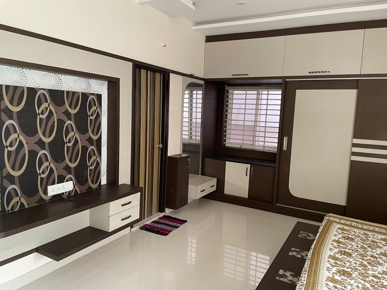Une chambre à coucher moderne avec un grand lit, une armoire, une coiffeuse et une fenêtre équipée de stores.
