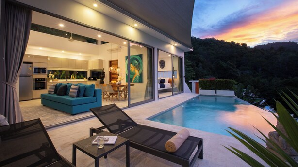 A modern house with a swimming pool, a dining area, and a living room with a sofa and chairs. - ZOG Villas (Koh Samui)