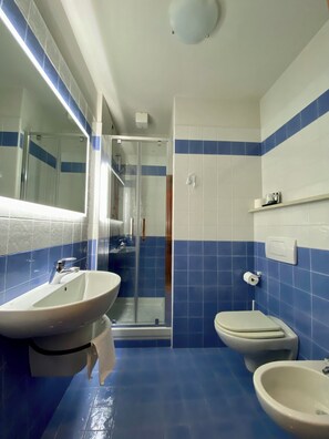 A bathroom with a glass-enclosed shower, a sink, a toilet, and a bidet. - CONTRA' CONTARINI (Valbrenta)