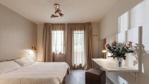A bedroom with a large bed, a bedside table with a lamp, a mirror, and a window with curtains. - CONTRA' CONTARINI (Valbrenta)