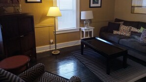 A living room with a sofa, a coffee table, a lamp, and a cabinet.