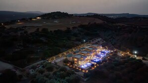A resort with multiple buildings, outdoor pools, and a well-lit pathway.