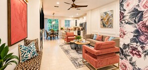 A modern living room with a sofa, coffee table, and a dining area with chairs.