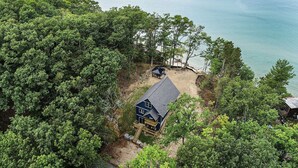 Ein abgelegenes Ferienhaus, umgeben von dichtem Wald, mit freiem Blick auf den See.
