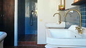 Ein Badezimmer mit zwei Waschbecken, einer Dusche und einer gefliesten Wand.