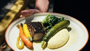 Ein Teller mit gegrilltem Fleisch, Gemüse und Kartoffelpüree.