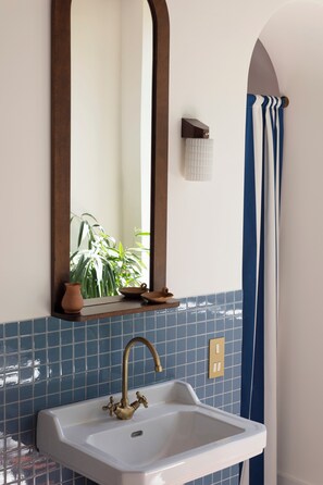 Een aparte badkuip en douche, een haardroger, handdoeken, zeep