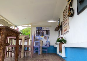 A cafe with a wooden table and chairs, a blue and white wall, and a sign with a QR code. - Casa Fibonacci (Titiribí)
