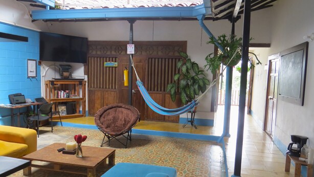 A cozy living area with a hammock, a sofa, a coffee table, and a bookshelf. - Casa Fibonacci (Titiribí)