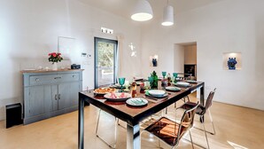 A modern dining area with a long table, chairs, and pendant lights. - Casale di Amelì 5, Emma Villas (Ostuni)