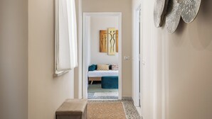 A hallway leading to a bedroom with a bed, pillows, and a bedside table. - Penthouse in the center of Rome, with terrace a few meters from the Conca d'oro Metro.  (Roma)