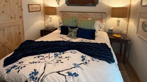 Un dormitorio con una cama grande, techo de madera y decoración rústica.