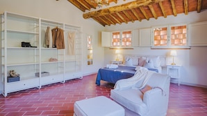 A hotel room with a bed, a seating area, a wardrobe, and a chandelier. - Villa / Independent home in Capannori with 3 bedrooms sleeps 6 (Capannori)