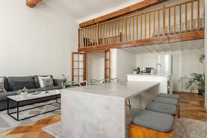 Una sala de estar moderna con un sofá, una mesa de centro y un comedor con una mesa y sillas.