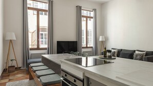 A modern kitchen with a central island, built-in appliances, and large windows. - L'Authentique - A Journey to Provence (Aix-en-Provence)