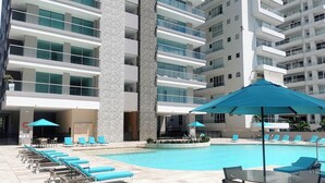 A modern hotel with a swimming pool, lounge chairs, and umbrellas. - Eden Loft in beautiful Santa Marta Colombia, "The Pearl of the Americas" (Santa Marta)