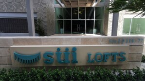 A building entrance with a sign reading 'SUI LOFTS' and a contact number. - Eden Loft in beautiful Santa Marta Colombia, "The Pearl of the Americas" (Santa Marta)