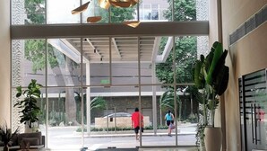 A spacious lobby with a modern chandelier, large windows, and a wet floor. - Eden Loft in beautiful Santa Marta Colombia, "The Pearl of the Americas" (Santa Marta)