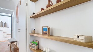 A clean, modern interior with wooden shelves displaying decorative items and a framed picture. - CASA BEIRA-MAR - Charming typical Moradia house in OLHAO -ROOFTOP and parking lot (Olhão)