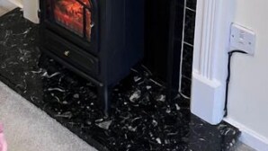A fireplace with a black tiled surround, a white mantel, and a modern electric stove below. - Cosy home in quiet cul-de-sac. Private fenced garden and free parking. (Wolverhampton)