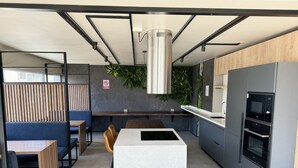 Una cocina moderna con una isla central, electrodomésticos integrados y una zona de estar con vistas.