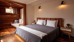 A bedroom with a wooden headboard, a large bed with white and gray bedding, two bedside tables with lamps, and a window with curtains. - Private villa only a short stroll to the beach/Organic shop (Cobano)