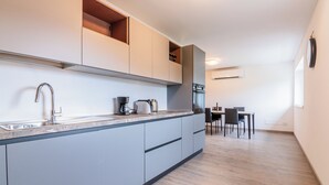 A modern kitchen with a built-in island, stainless steel appliances, and a dining area with a table and chairs.