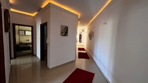 A hallway with white walls, red carpets, and a ceiling light fixture. - Naxxar 3-Bedroom Spacious Family Home with Private Roof by Malta Weekend (Naxxar)