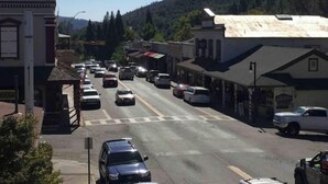 A street view with buildings, cars, and a clear sky.