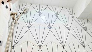 A bathroom with white tiles and black lines forming a geometric pattern.