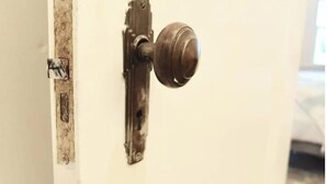 Una puerta con un pomo redondo y un cierre metálico.