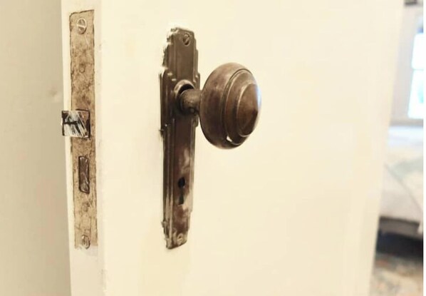 A door with a round knob and a metal latch.