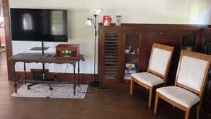 A living room with a television, a radio, a lamp, and wooden furniture.