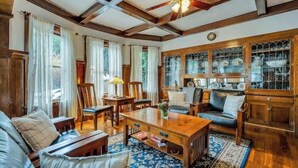 A traditional room with wooden beams, a ceiling fan, a fireplace, and a dining area with chairs and a table. - Luxury King Room. Steps to Napa Valley Wineries, Spas & Fine Dining! (Calistoga)
