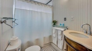 Ein Badezimmer mit Toilette, Waschbecken und Duschvorhang.