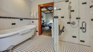 Un baño moderno con una bañera independiente, una zona de ducha con mampara de vidrio y un suelo con diseño.